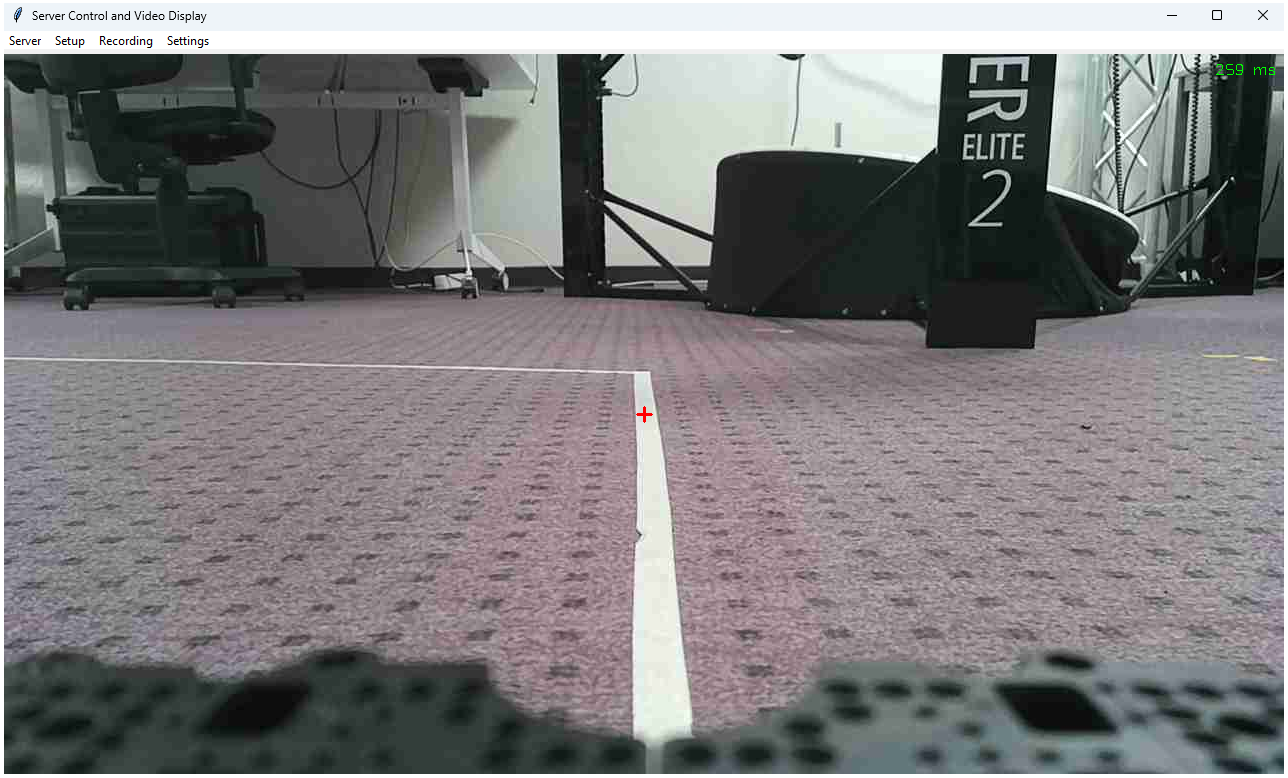 The operator’s interface displaying the video feed from the UGV’s onboard camera. A red cross at the center of the view serves as a reference marker, helping operators align the UGV with the path. The interface also shows the system delay in the top-right corner.